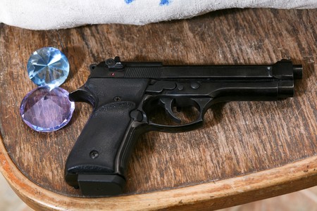 An image of a gun and gems on a chair