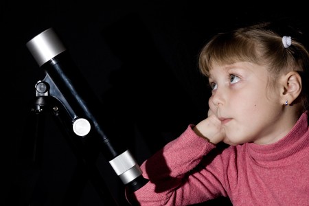 An image of a girl and a telescope on dark backgroundの写真素材