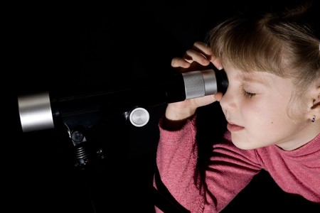 An image of a girl looking into a telescopeの写真素材