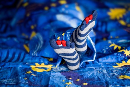 Stock photo: an image of little girl's feet in striped socks on a bedの写真素材