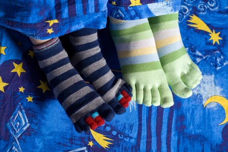 Stock photo: an image of two pairs of funny feet in striped socks