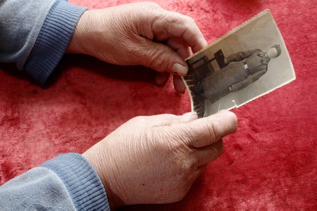 An image of old hands holding old photo の写真素材