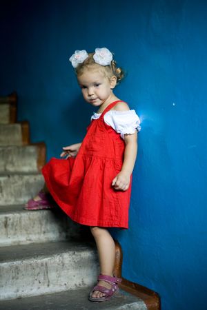 A beautiful little child standing at the wallの写真素材