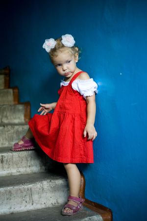 A beautiful little girl standing at the wallの写真素材
