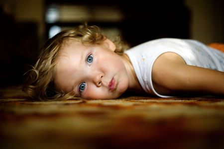 An image of little girl lying on the floorの写真素材