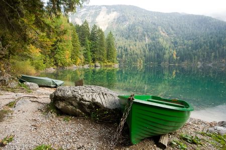 An image of a green boat at beautiful lakeの写真素材