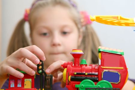 An image of a girl playing with a toy-trainの写真素材