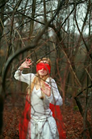 An image of girl with red blindfold in a forestの写真素材