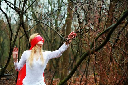 An image of young woman with red blindfold in a forestの写真素材