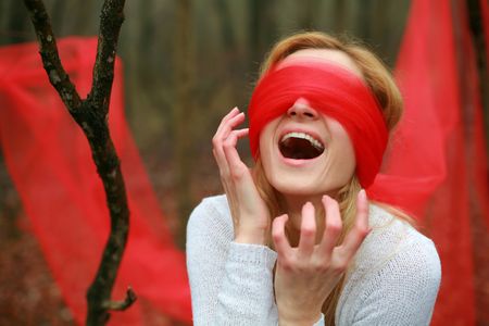 Screaming  blindfolded woman in the woodsの写真素材