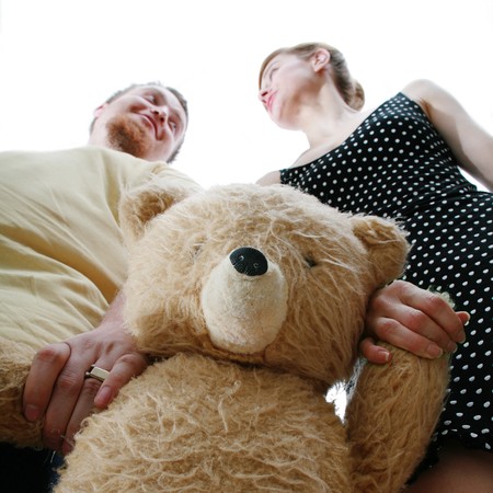 An image of a man and a woman with a teddy-bearの写真素材