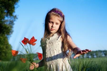An image of a beautiful girl in the field with poppiesの写真素材