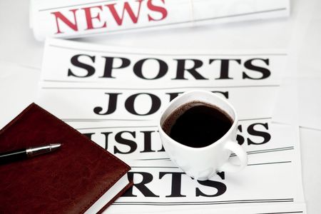 An image of a cup of coffee and a newspaper on the tableの写真素材