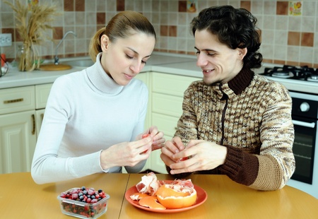 An image of young couple eating at kitchenの写真素材