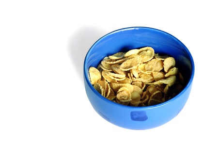 Cereal flakes in a blue bowl on white background