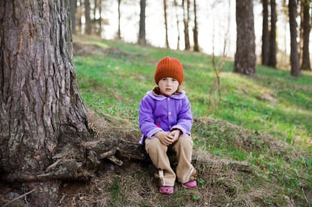 An image of a little girl in a red cap in the forestの写真素材