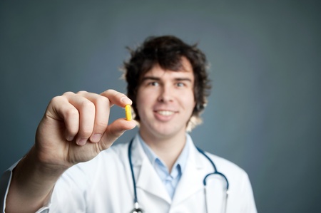 An image of a young doctor with a pill in his handの写真素材