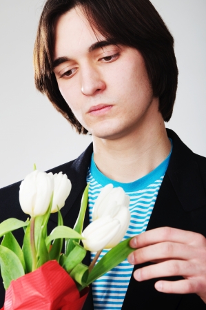 An image of man with white tulips on gray backgroundの写真素材