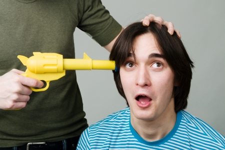 A man with a gun at his headの写真素材