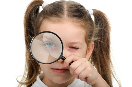 Girl holds in his hand a magnifying glassの写真素材