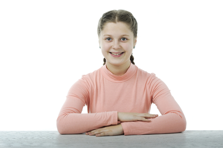 Little girl at the table in school isolated on whiteの写真素材