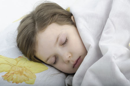 little girl sleeping in her bedの写真素材