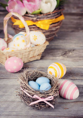 Easter eggs in a nest on a wooden surface