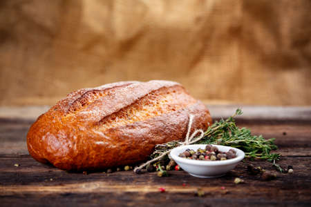 Fresh bread and spices on a wooden surfaceの写真素材
