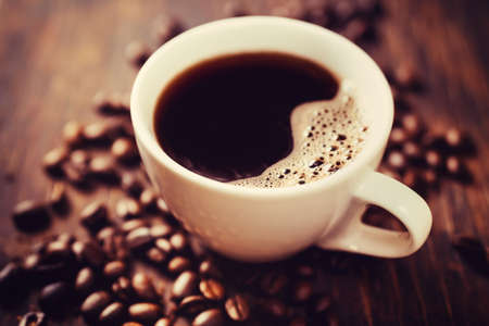 coffee cup and beans, on wooden tableの写真素材