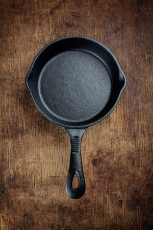 Vintage cast iron skillet  on rustic wood background.の写真素材