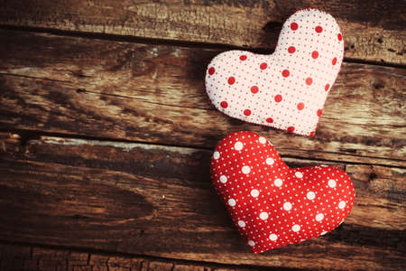Two hearts made of cloth on a wooden surface