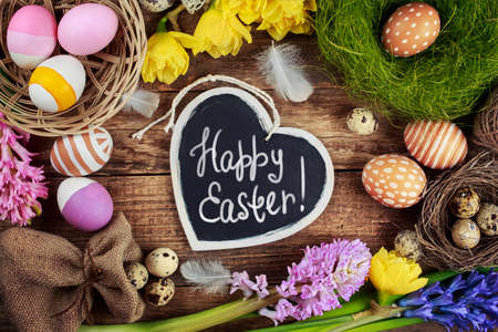 Black board with text - Happy Easter. Colorful Easter Eggs and flowersの写真素材