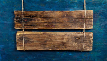 blank wooden signboard on aged wooden blue wallの写真素材