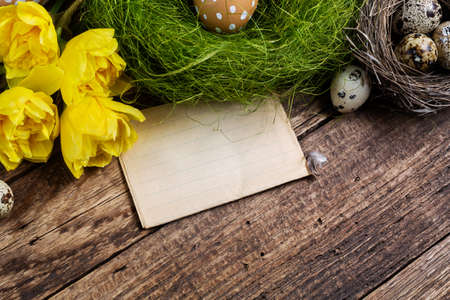 Easter decorations  with card on old wooden tableの写真素材