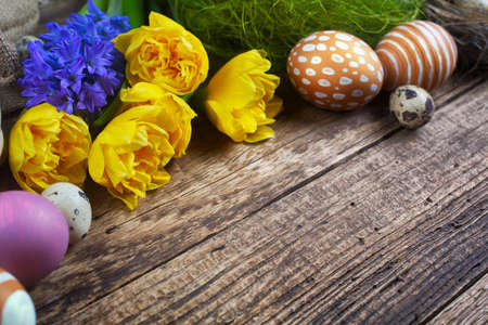 Easter decorations on a wooden background, eggs and flowersの写真素材