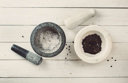 Two mortars with spices and sea salt on a light wooden backgroundの写真素材