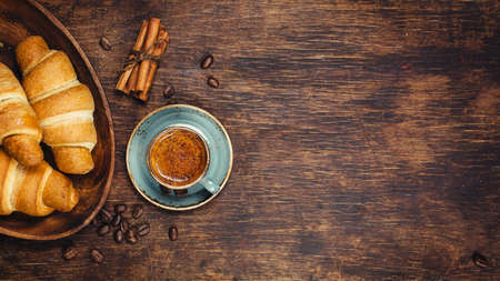Croissants and coffee on a rustic dark background. Food background with copyspaceの写真素材