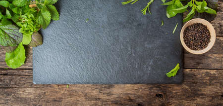 Herbs and Black Pepper.  Slate and wood background.の写真素材