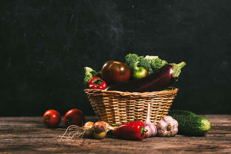 Organic vegetables in a basket on a dark backgroundの写真素材