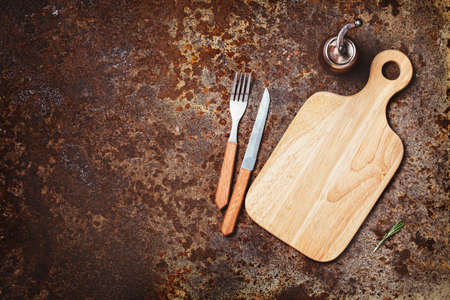 Cutting boards, knife and fork on a rustic background. Lots of copy spaceの写真素材
