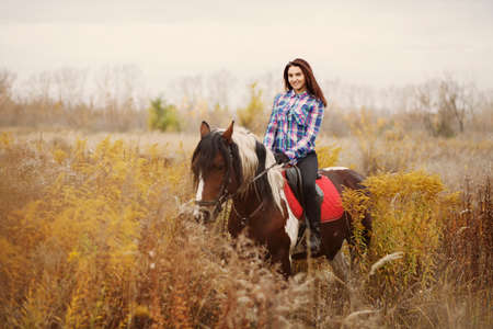 Woman and horse. Beautiful girl riding a horse in countryside.