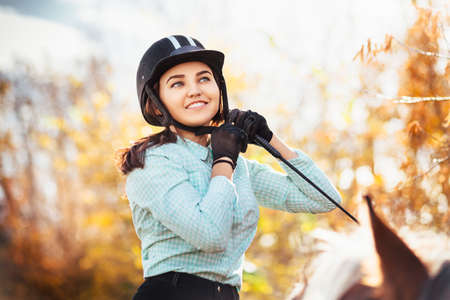 Beautiful young woman on a horseback, outdoor portrait