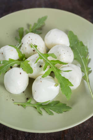 Mozzarella and arugula on a rustic dark backgroundの写真素材