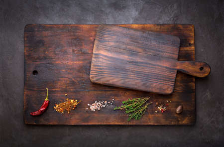 Spice for cooking and empty cutting boards on a dark background. Food background with copyspace. Top viewの写真素材