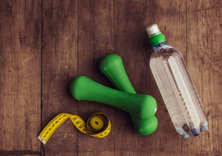 Bottle of water, dumbbells and tape measure. Healthy lifestyle, fitness. Concept of weight loss.の写真素材