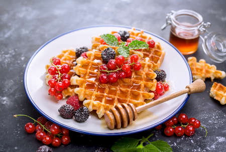 Waffles with fresh berries and honey. Breakfast with Belgian wafflesの写真素材