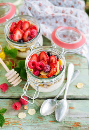 Yogurt and muesli with berries on a table, selective focus. Healthy food, diet and cooking concept.の写真素材