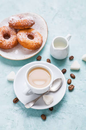 Donuts and coffee on blue background. Shallow DOF, top viewの写真素材