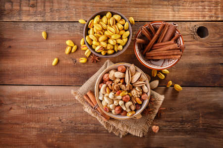 Mix of nuts and cinnamon on a old rustic table.の写真素材