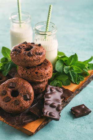 Chocolate doughnuts with milk and pieces of chocolate, toned imageの写真素材